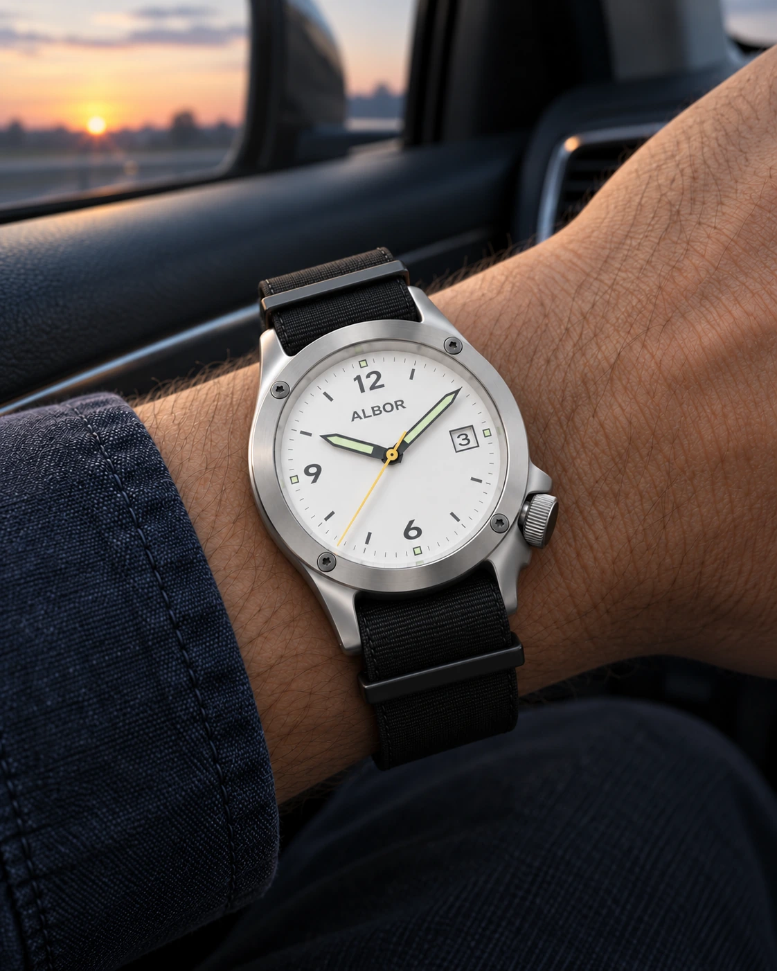 Concept visualisation of the revised ALBOR with integrated lugs and a black NATO strap on an anonymous adult wrist inside a parked vehicle