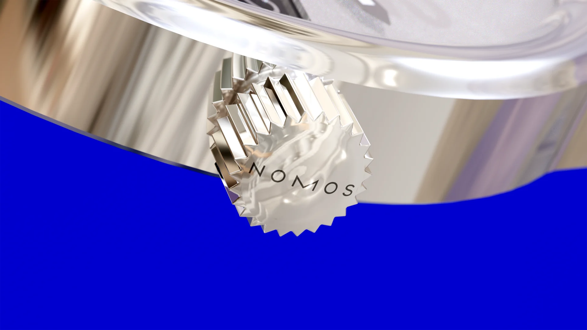 Macro NOMOS crown and polished steel case against blue