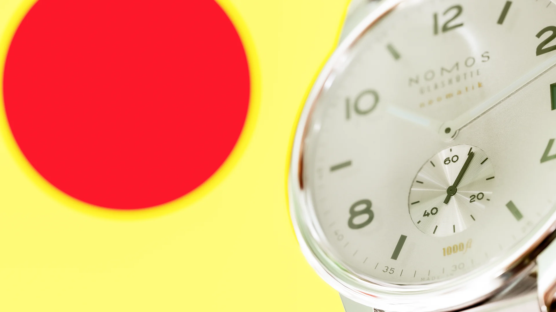 NOMOS watch crossing yellow and red geometric circles
